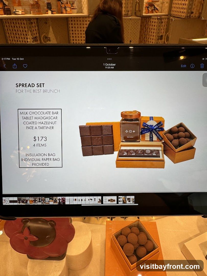A display of a Louis Vuitton 'Spread Set' for brunch, featuring a milk chocolate bar, Madagascar coated hazelnut pate a tartiner, and chocolates. The set is priced at $173 and includes an insulation bag and individual paper bag.
