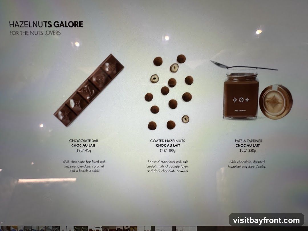 A display of hazelnut-themed chocolate products. Includes a chocolate bar, coated hazelnuts, and a jar of chocolate spread.