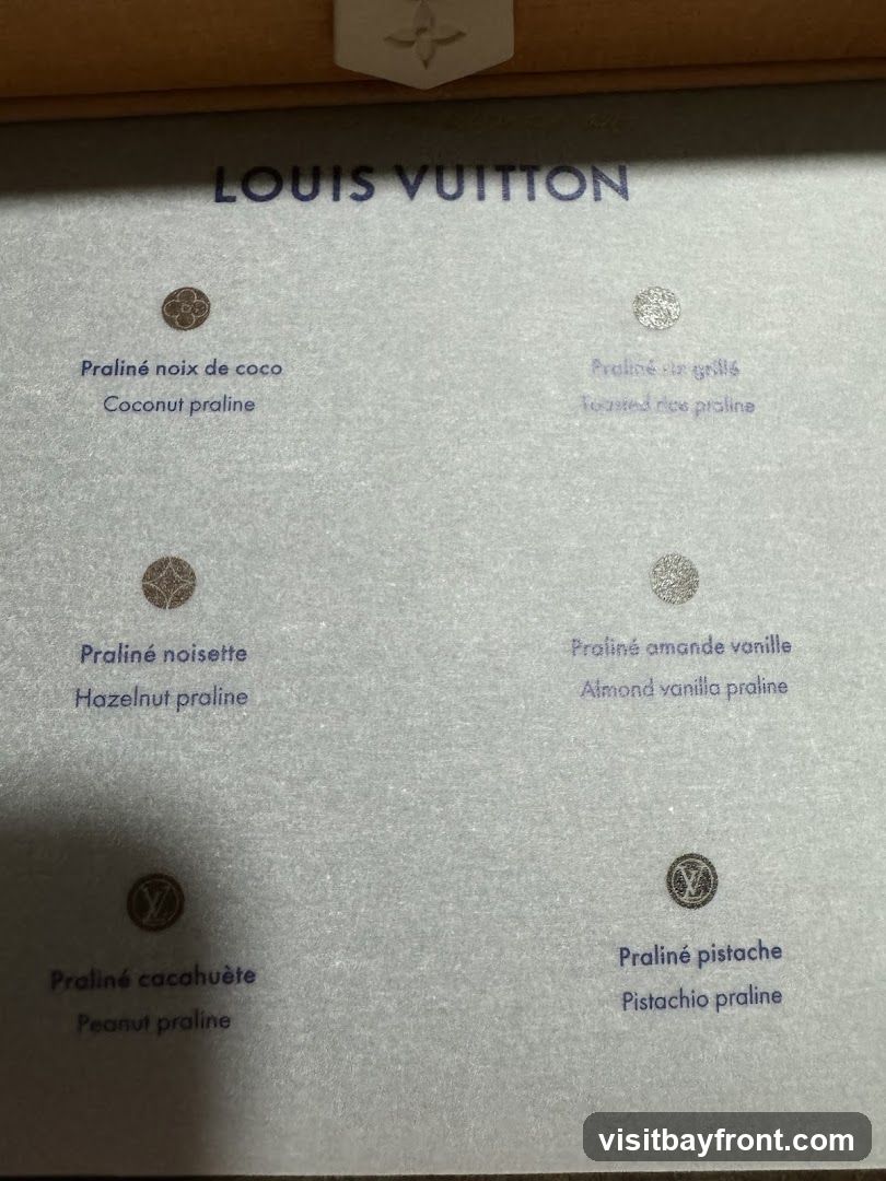 A display of different praline flavors offered by Louis Vuitton, with each flavor listed in French and English, accompanied by a small circular emblem.