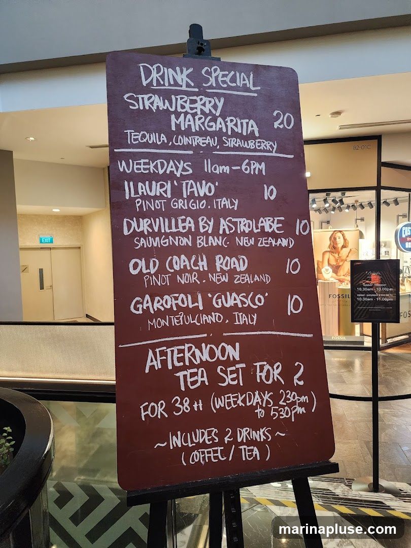 A chalkboard menu displaying drink specials and an afternoon tea set.