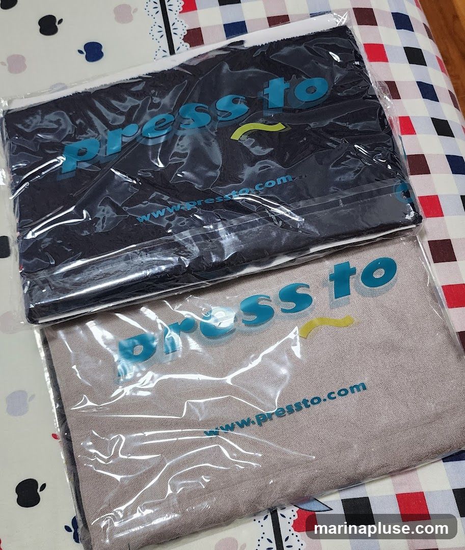 Two folded fabric items, likely towels or cloths, are shown in clear plastic packaging. Both items display the logo "press to" in blue lettering with a yellow wavy line. Below the logo, the website "www.pressto.com" is visible on both. The items are laid out on a patterned surface.