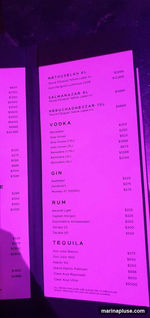 A menu listing various large format bottles of champagne, vodka, gin, rum, and tequila, with prices.