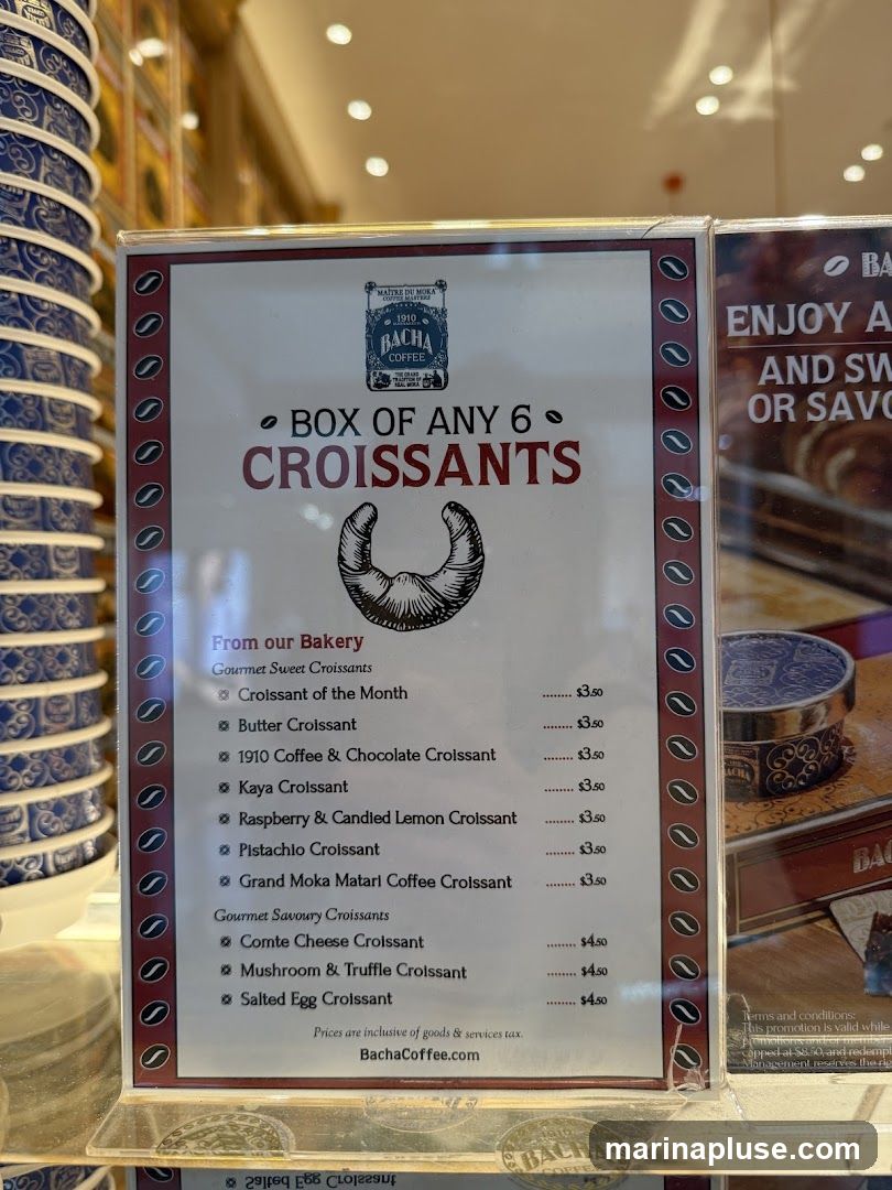 A menu board advertising a box of 6 croissants from Bacha Coffee's bakery. It lists gourmet sweet and savoury croissant options with prices.