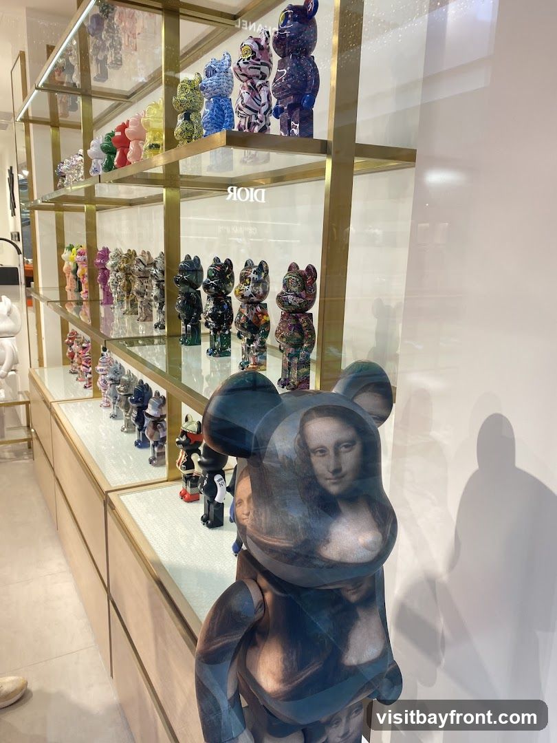 A display of various Bearbrick collectible figures on shelves in a store. The figures are colorful and feature different designs, including one with the Mona Lisa artwork. The store interior is visible with wooden cabinets and glass shelves.