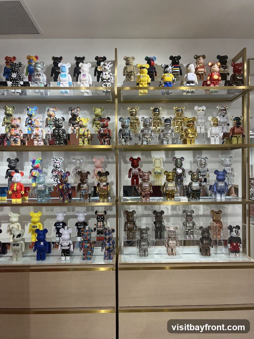Shelves filled with various collectible figurines, primarily in the shape of bears, in different colors, designs, and sizes. Some figurines are displayed in clear cases. The figurines are arranged on multiple shelves within a retail or display setting.