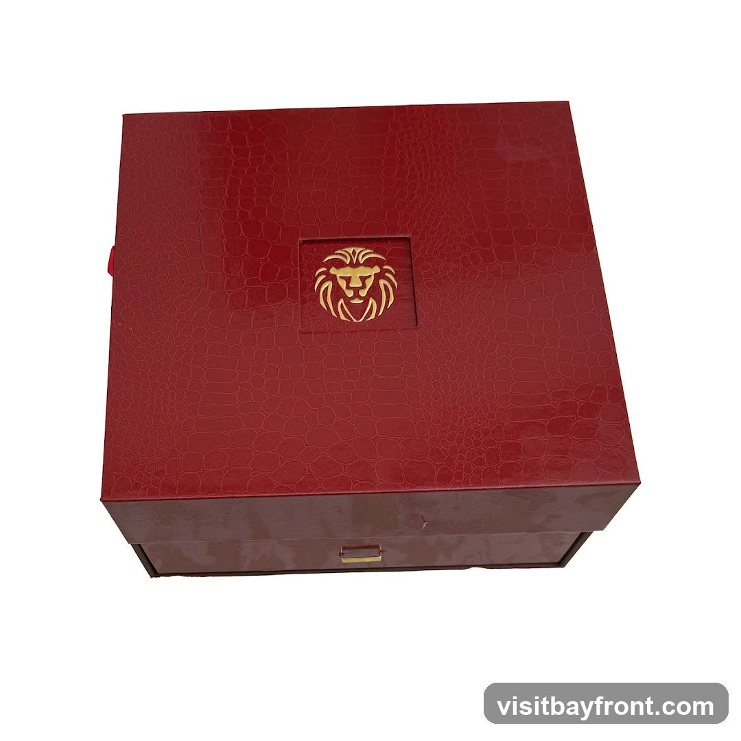 A red, textured gift box with a gold lion emblem on the lid. The box has a drawer-like compartment at the bottom with a small gold handle.