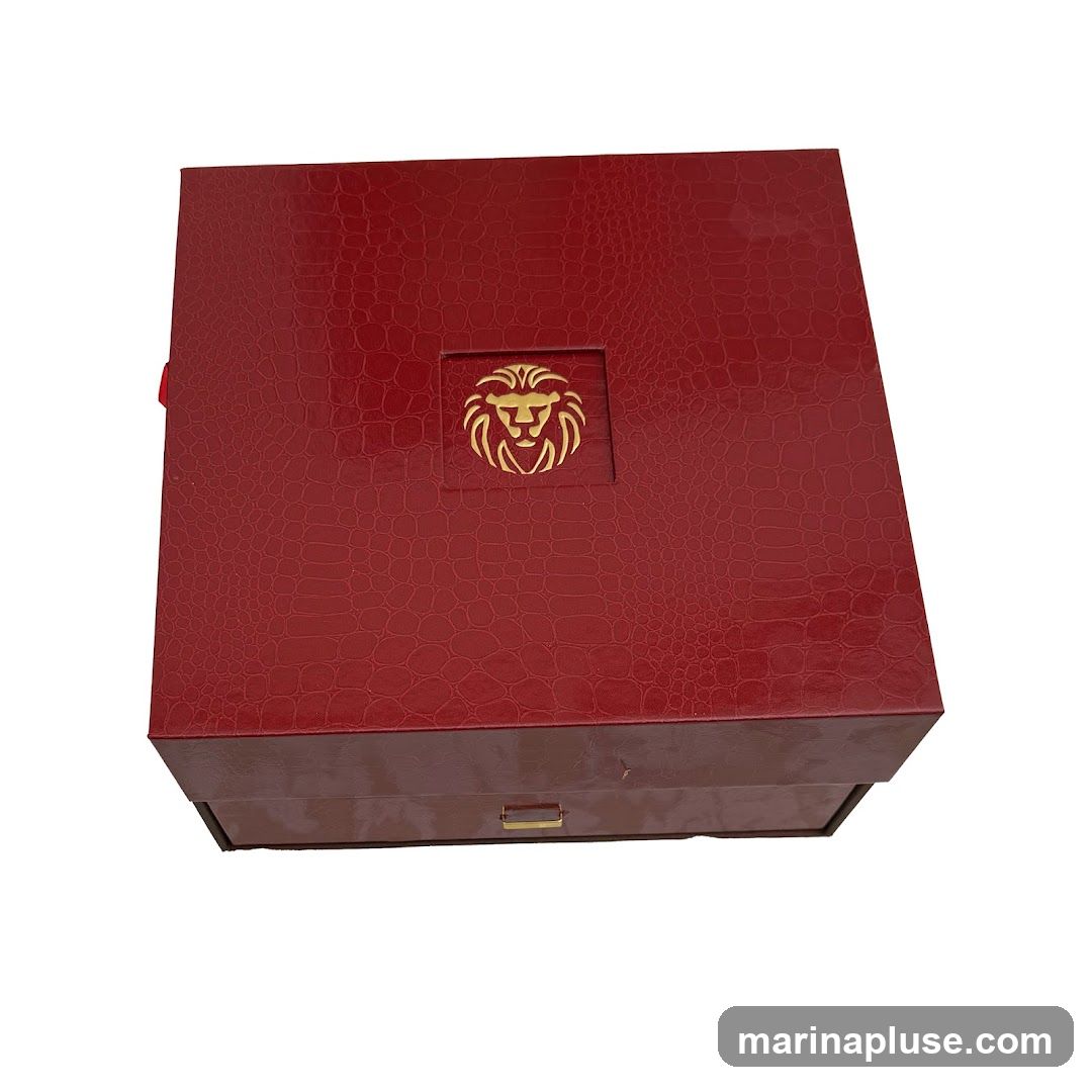 A red, textured gift box with a gold lion emblem on the lid. The box has a drawer-like compartment at the bottom with a small gold handle.