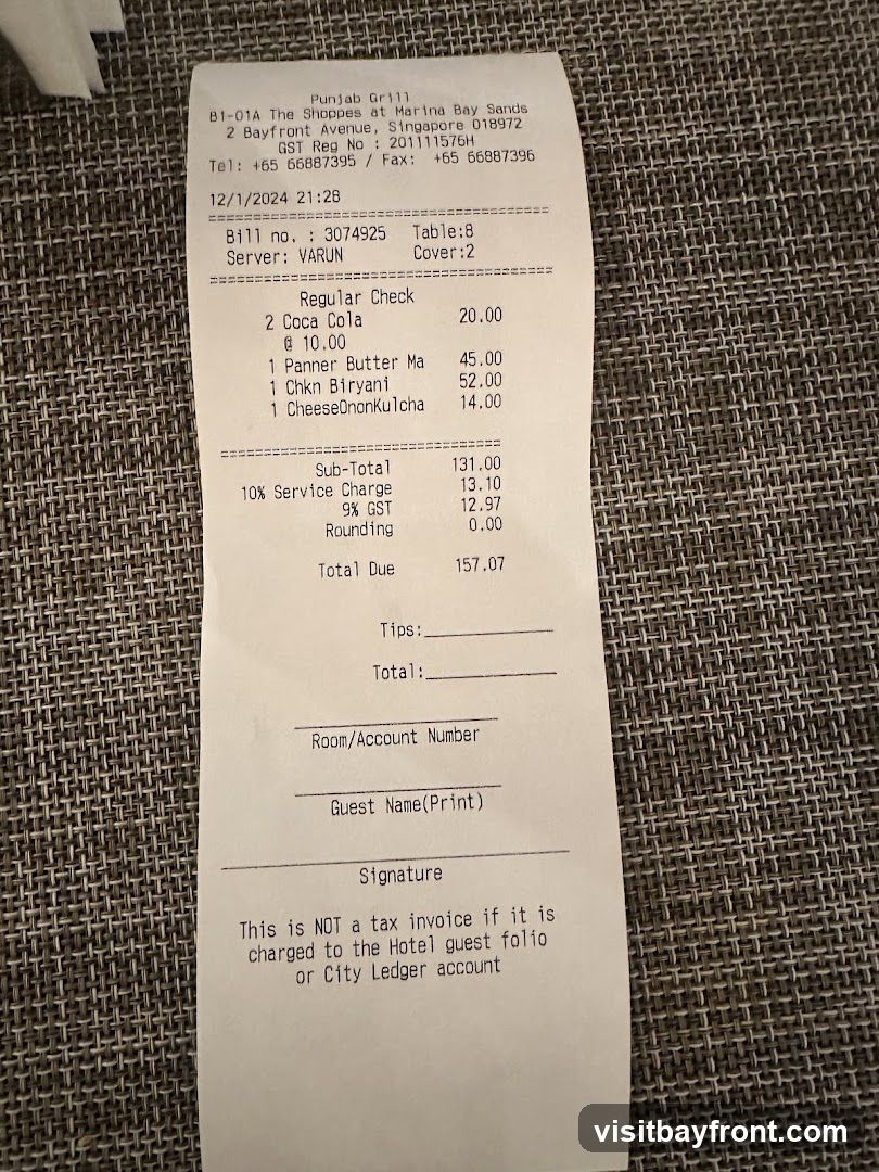 A restaurant bill from Punjab Grill at The Shoppes at Marina Bay Sands. The bill details a regular check with items including Coca Cola, Panner Butter Ma, Chkn Biryani, and CheeseOnonkulcha. It also includes service charge, GST, and a total due amount.