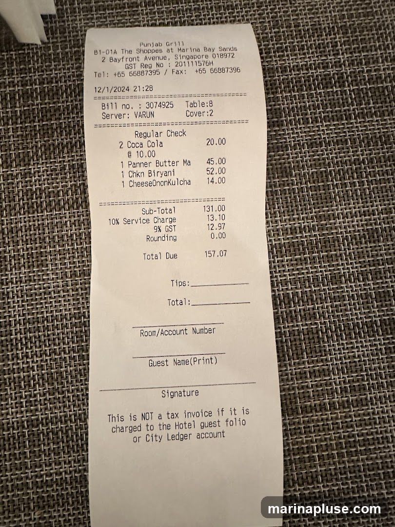 A restaurant bill from Punjab Grill at The Shoppes at Marina Bay Sands. The bill details a regular check with items including Coca Cola, Panner Butter Ma, Chkn Biryani, and CheeseOnonkulcha. It also includes service charge, GST, and a total due amount.