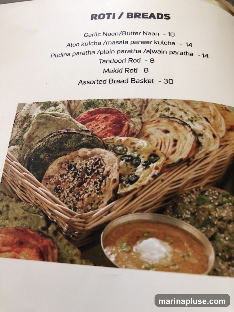 A basket of assorted Indian breads and a bowl of curry.