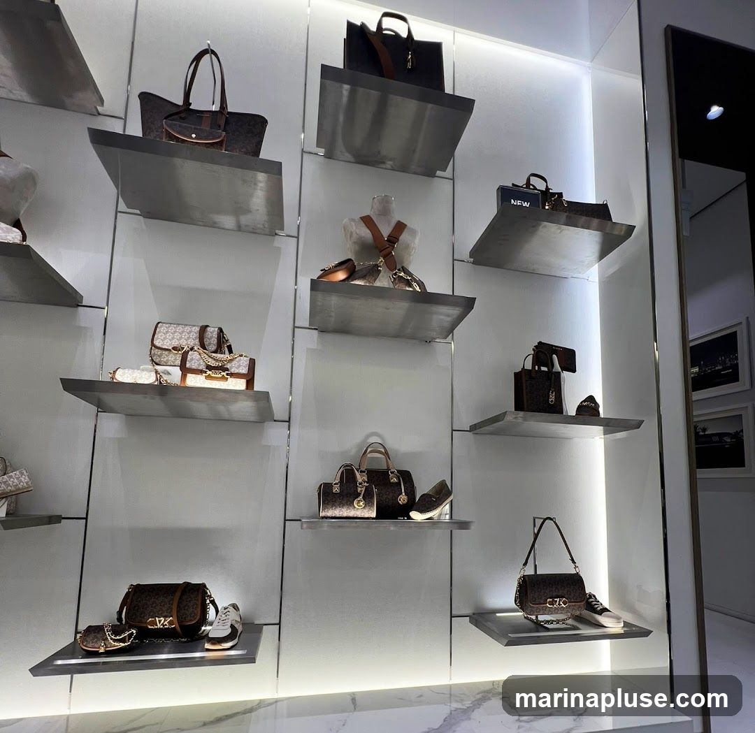 A well-lit display of various handbags and shoes arranged on sleek, modern shelves. The items feature a consistent brand pattern, suggesting a retail environment.