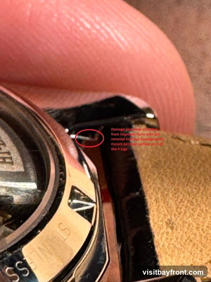 Close-up view of a watch lug showing damage and deep scratches. Text indicates the damage resulted from improper force with a pin removal tool and misalignment, occurring on the inner surface of three of the four lugs.