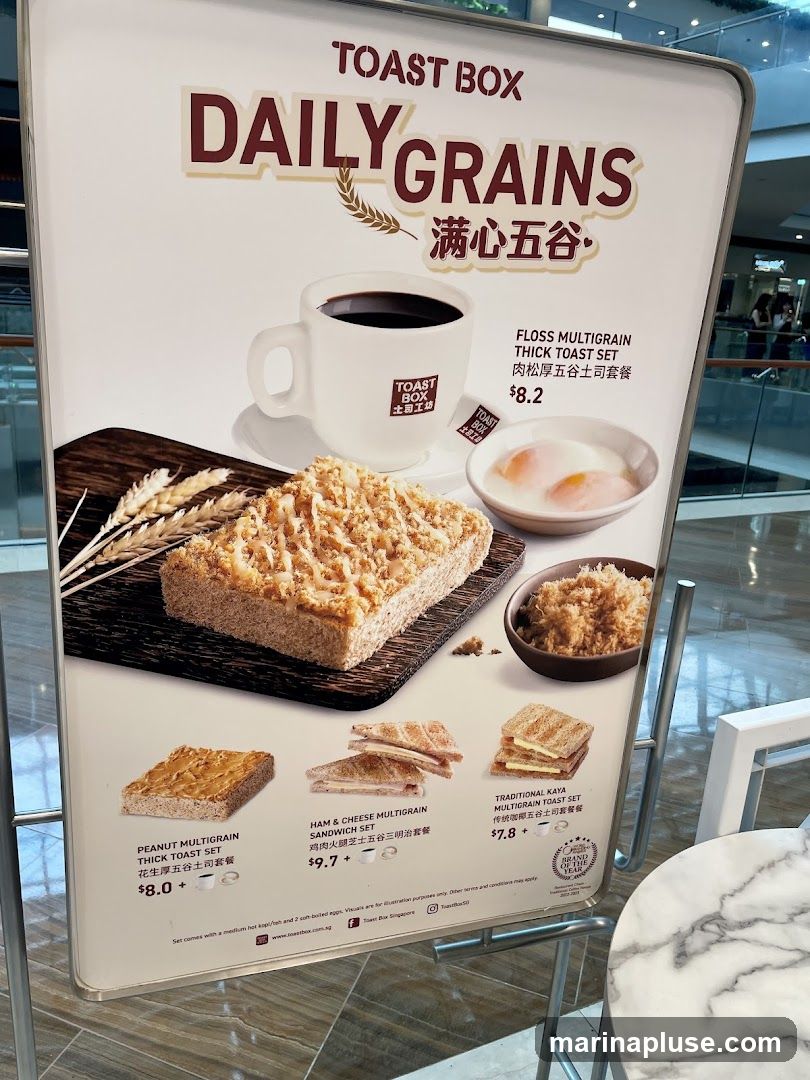 A menu board from Toast Box showcasing their Daily Grains menu with various toast and sandwich sets.