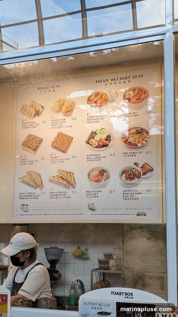 A menu board displaying various toast sets and Asian delight sets.