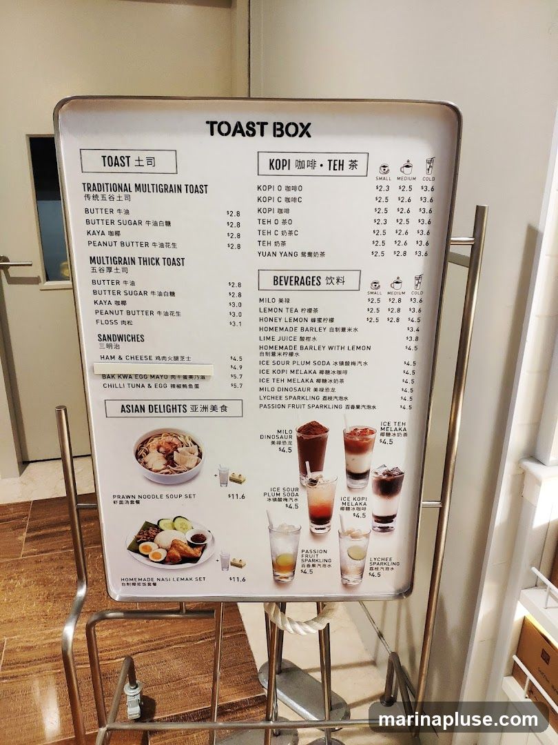 A menu board for Toast Box featuring traditional multigrain toast, thick toast, sandwiches, Asian delights, Kopi, Teh, and beverages.