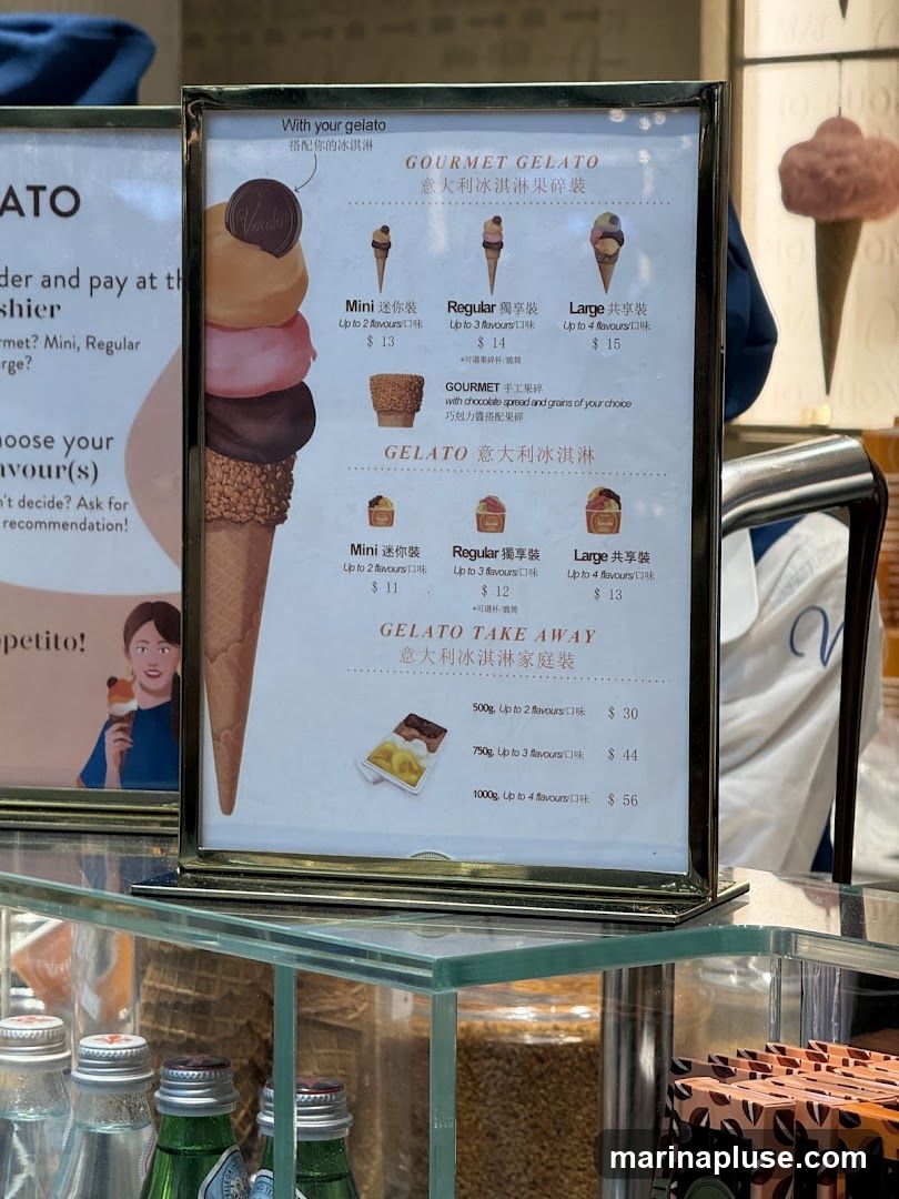 A menu board displaying various gelato options, including GOURMET GELATO and GELATO TAKE AWAY.