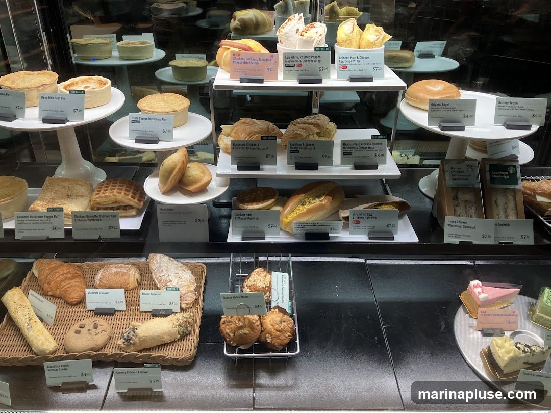 A display case filled with various food items including pies, sandwiches, pastries, and cakes.
