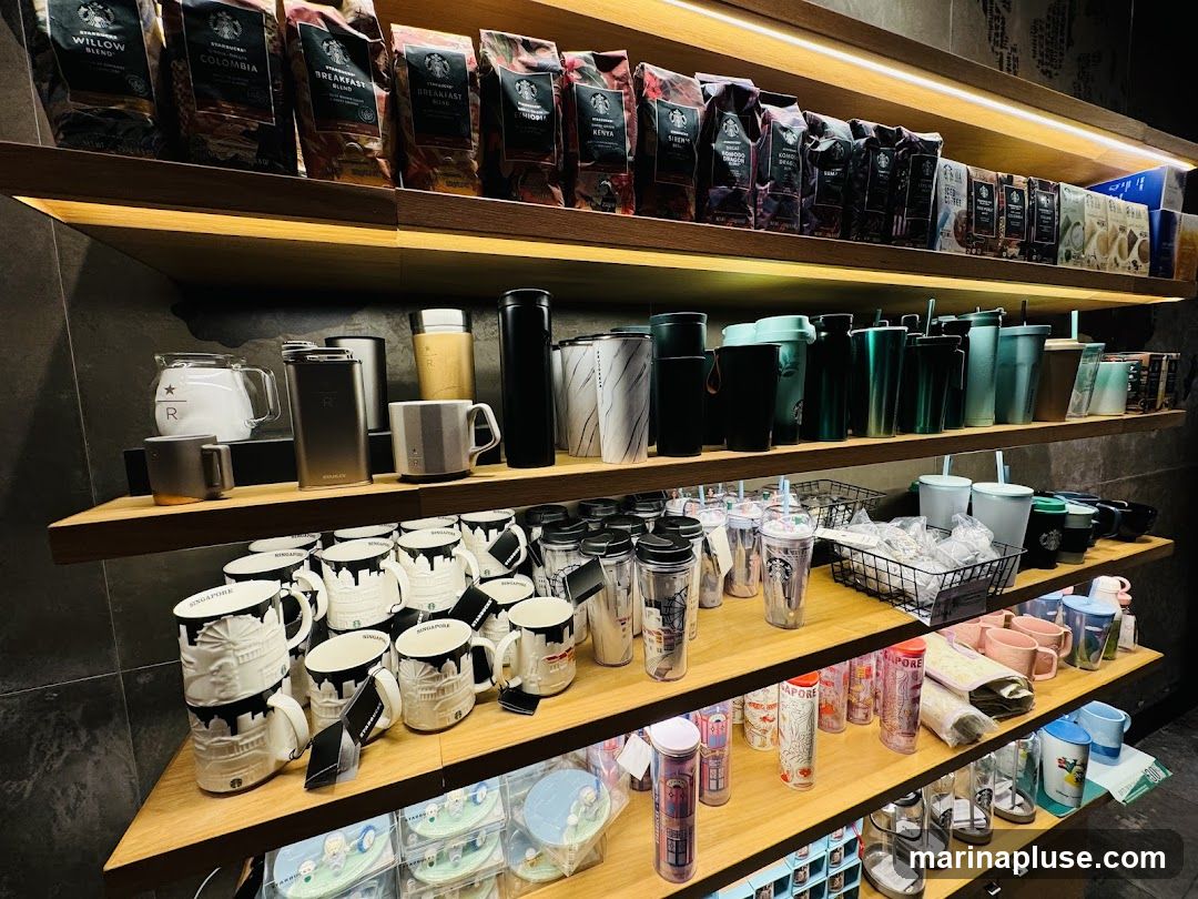 Shelves stocked with various Starbucks merchandise, including bags of coffee beans, reusable cups, tumblers, mugs, and other drinkware. The items are arranged neatly on wooden shelves, with some items displayed in baskets.
