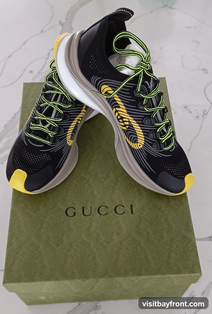 A pair of black and yellow Gucci sneakers with neon green laces are placed on top of a green Gucci shoebox. The sneakers have a modern, athletic design with intricate patterns and the Gucci logo visible on the side. The shoebox features the embossed Gucci pattern and the brand name in gold lettering.