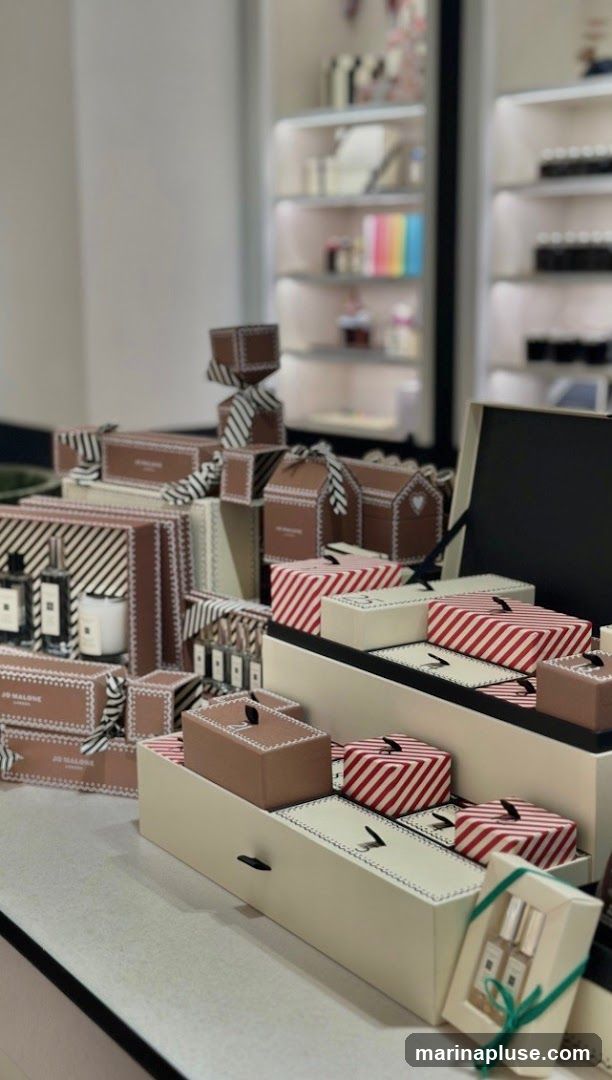 A display of various gift boxes, some with red and white stripes, others in brown with white trim. Several bottles of perfume and a candle are visible on the left. The background shows shelves stocked with products.