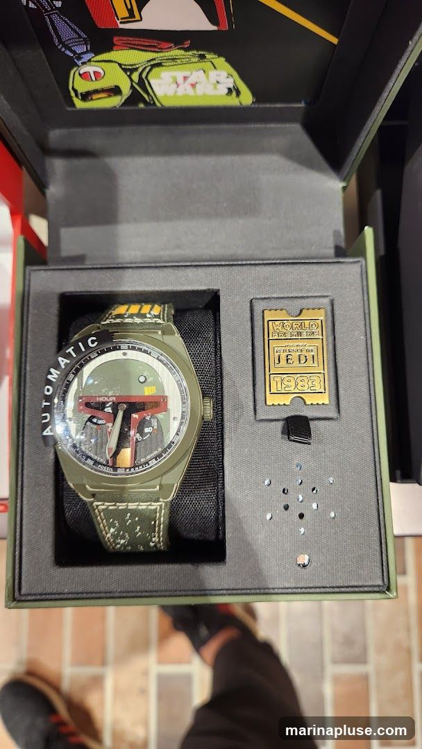 A limited edition Star Wars Boba Fett themed automatic watch is displayed in its presentation box. The watch face features a design inspired by Boba Fett's helmet. The box also contains a commemorative pin for the "Return of the Jedi" world premiere in 1983. The interior of the box lid has a graphic of Boba Fett and the Star Wars logo.