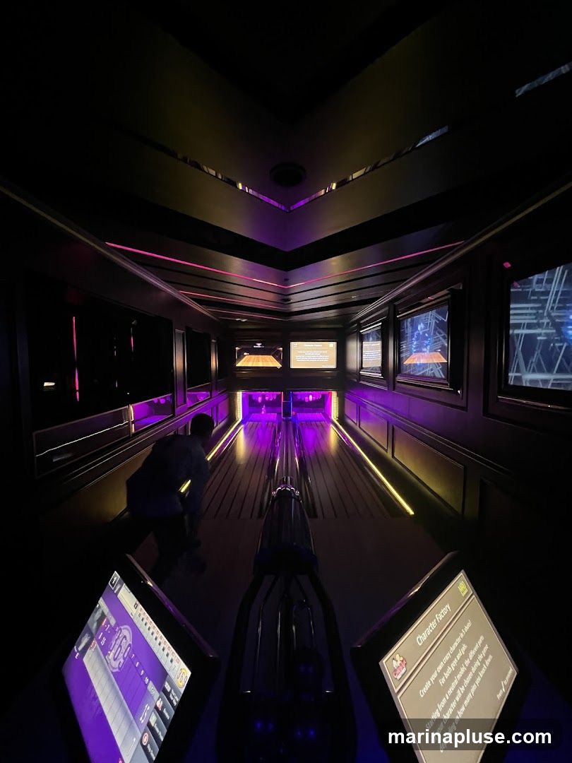 A person is preparing to bowl in a dimly lit bowling alley. The lanes are illuminated with purple and yellow lights. There are screens on the sides displaying game information and a "Character Factory" station where users can create their own characters.