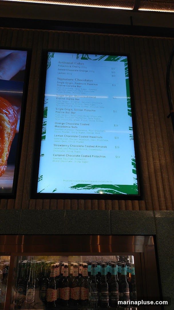 A digital menu displaying artisanal cakes and signature chocolates.