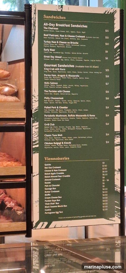A menu board displaying various sandwiches and viennoiseries with prices.