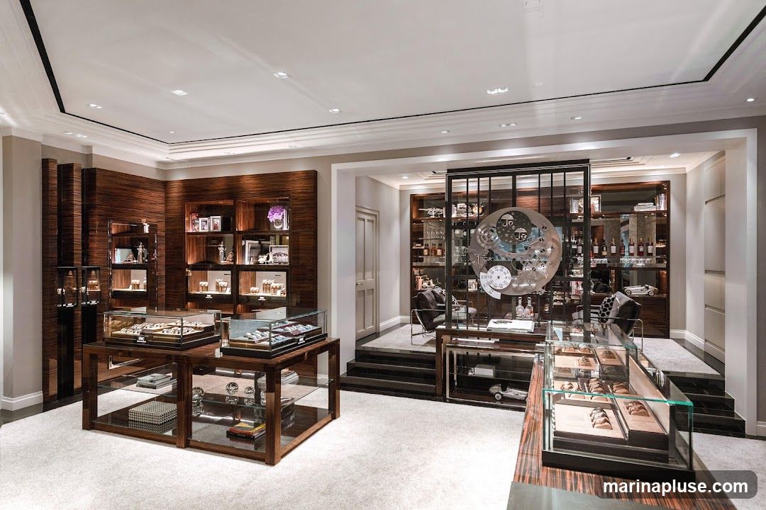 The interior of a high-end watch store, featuring elegant wooden displays, glass showcases filled with watches, and decorative elements. The store has a sophisticated ambiance with soft lighting and plush carpeting.