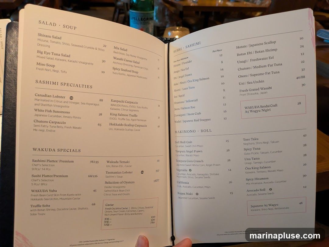 A menu with sections for Salad Soup, Sashimi Specialties, Wakuda Specials, Sushi Sashimi, and Makimono Rolls.