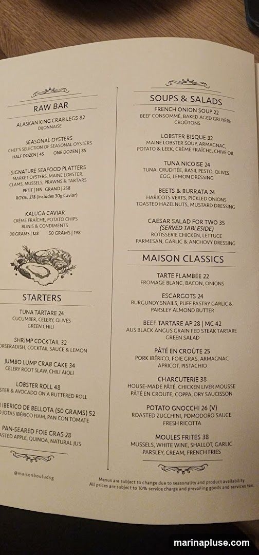 A menu with sections for Raw Bar, Soups & Salads, Starters, and Maison Classics.