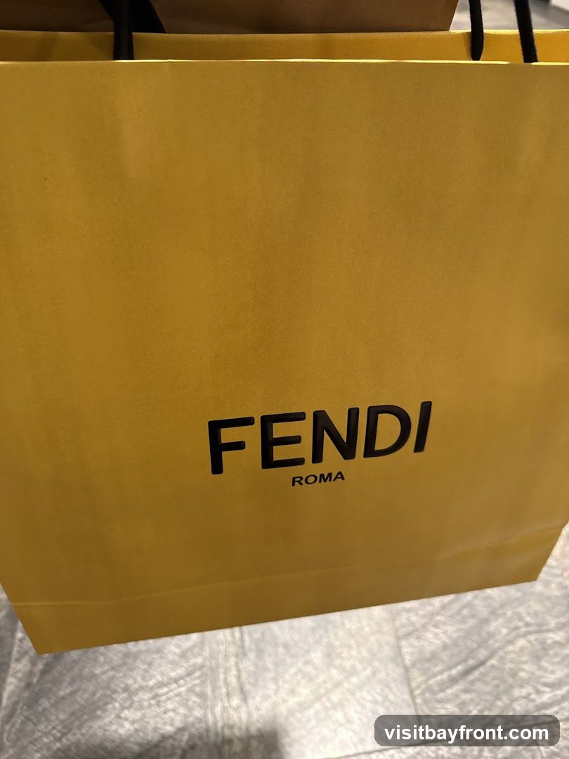 A close-up shot of a yellow Fendi shopping bag with the Fendi Roma logo printed in black.