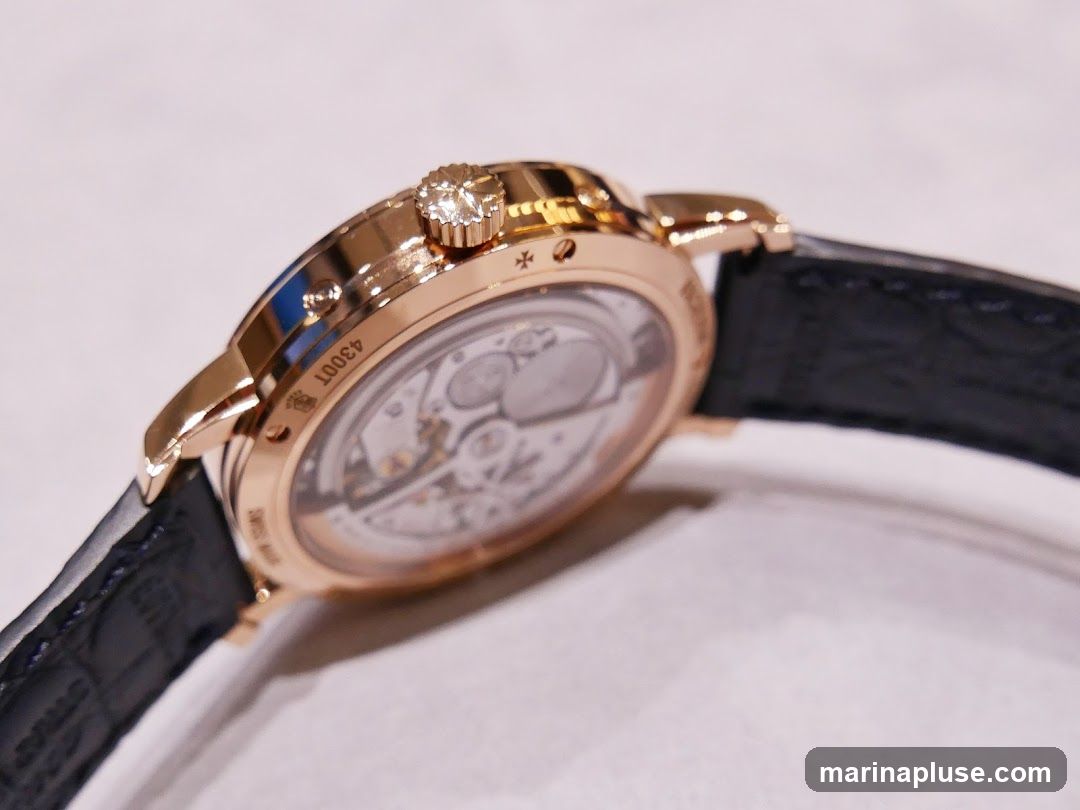 A close-up, side view of a rose gold watch with a black alligator leather strap. The watch features a diamond-set crown and an exhibition caseback revealing the intricate mechanical movement. Engraved text on the case reads "4300T" and "SWISS MADE".