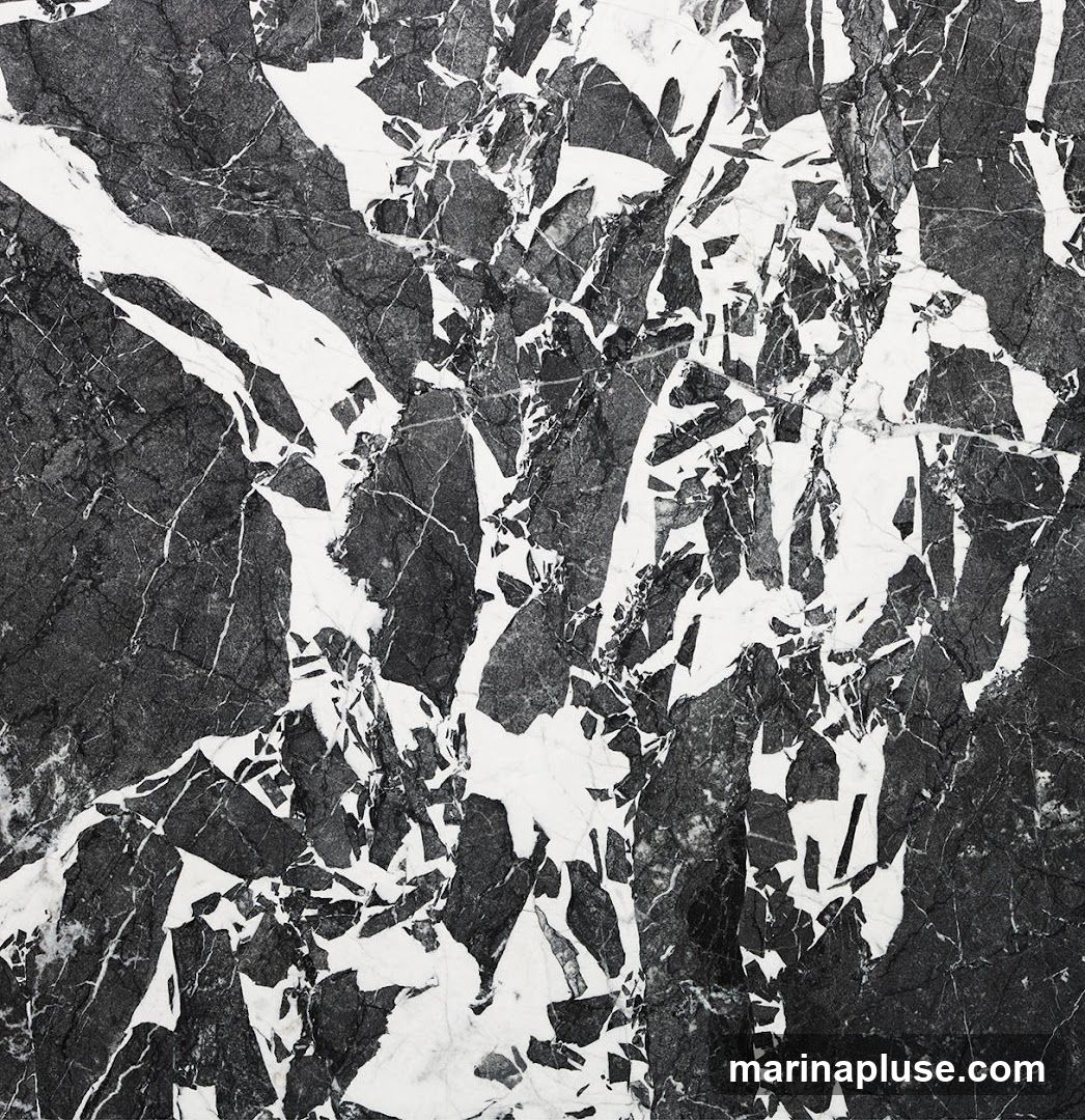 A close-up, abstract view of a black and white marble surface, showcasing its natural veining and fractured patterns.