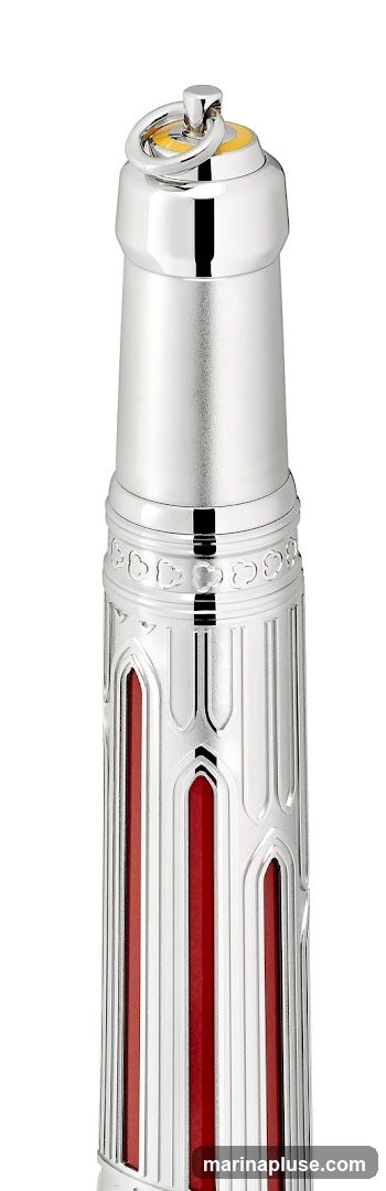 A close-up, detailed view of the top portion of a silver pen with red accents. The pen features intricate detailing, including a ring and a yellow accent at the very top, followed by a band with decorative cutouts. The main body of the pen has vertical grooves with red inlays.