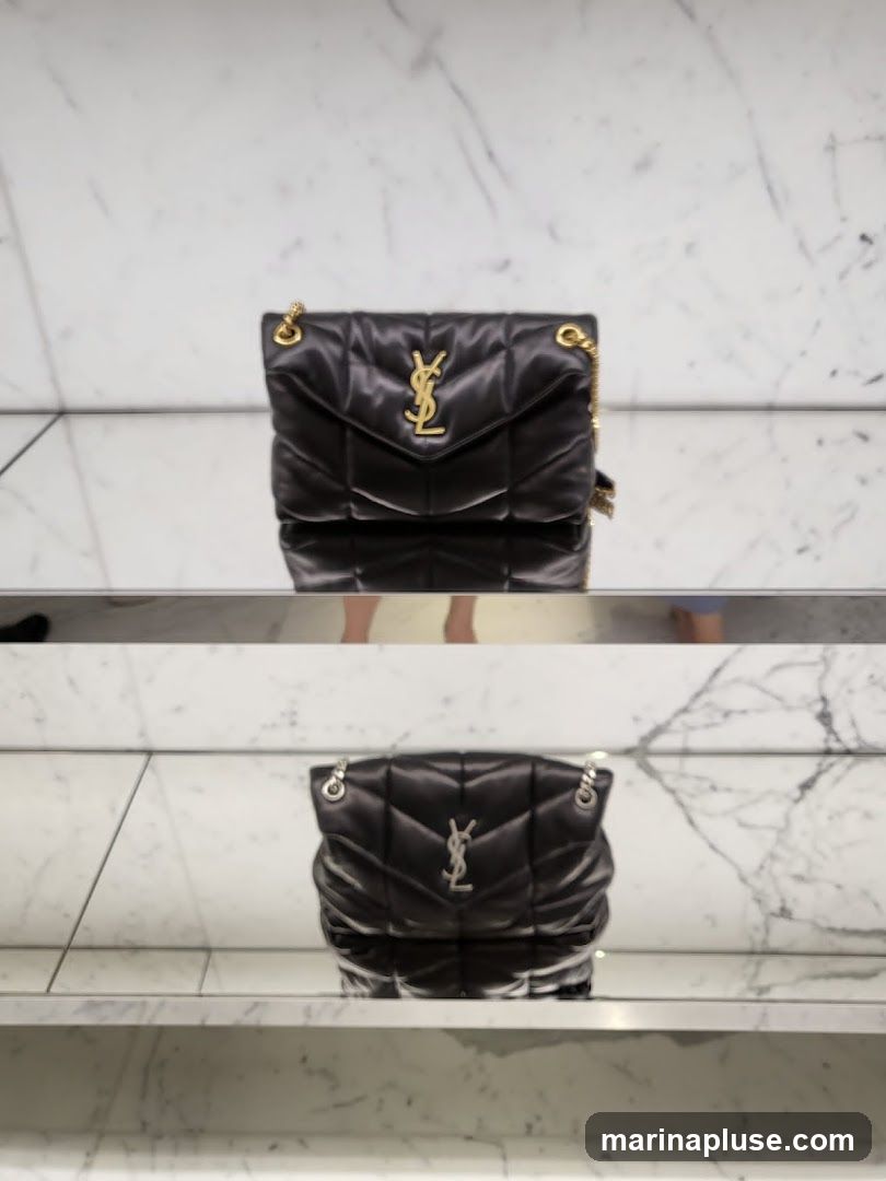 Two black YSL handbags are displayed on shelves with a marble-patterned background. The top handbag has a gold YSL logo, while the bottom handbag has a silver YSL logo.