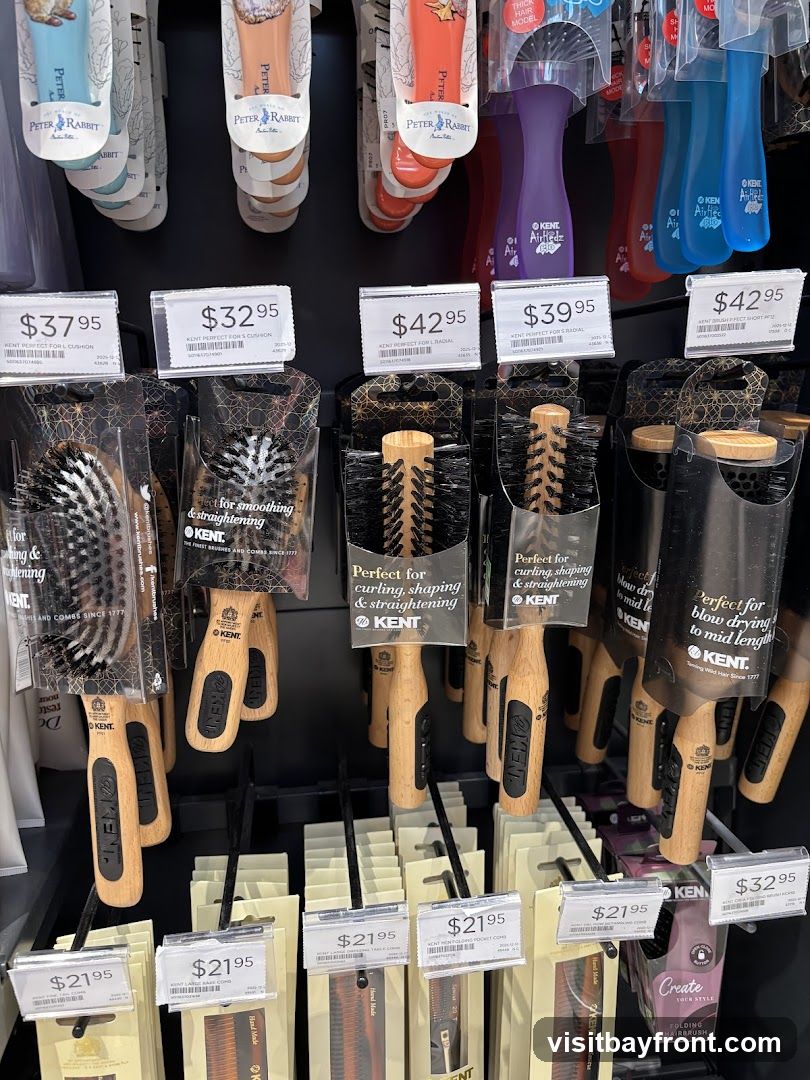 A retail display featuring various hair brushes and combs from the brand KENT, with some items also featuring Peter Rabbit branding. Prices range from $21.95 to $42.95.