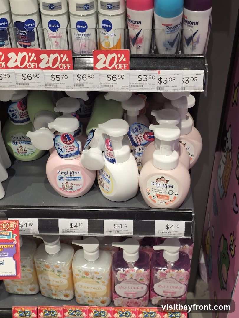 A retail display featuring various personal care products. The top shelf shows several deodorants from brands like Nivea and Rexona. Below, there are bottles of Kirei Kirei foaming hand soap in different scents, including "Anti-bacterial" and "Chamomile". The bottom shelf displays more hand soaps, labeled "Chamomile" and "Rose & Orchid". Red "20% OFF" signs are visible on the shelves.