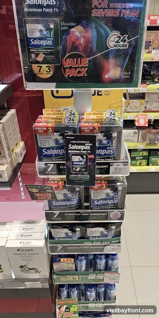 A retail display featuring Salonpas Diclofenac Patch 1% products. The display includes promotional signage highlighting "Value Pack" and "For Severe Pain," with graphics illustrating shoulder and back pain relief. Various sizes and pack counts of the patches are visible, along with some bottles of what appears to be medication or supplements on lower shelves.