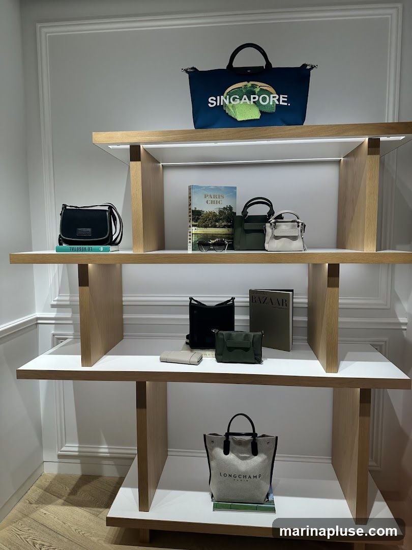 A retail display featuring several handbags and books on wooden shelves. The top shelf has a blue tote bag with