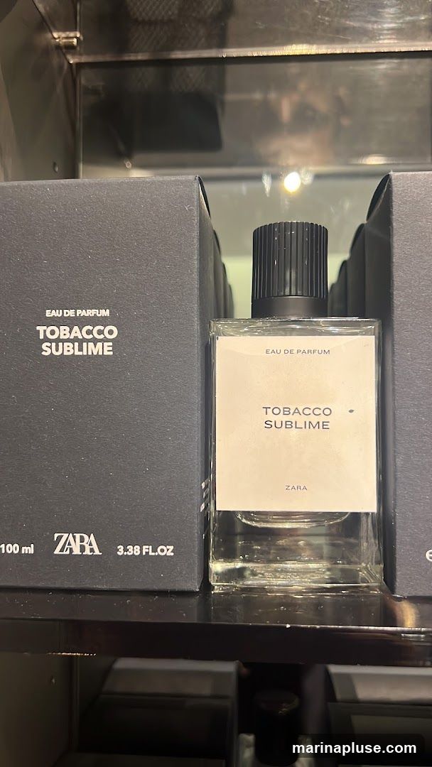 A bottle of Tobacco Sublime Eau de Parfum by Zara is displayed next to its packaging. The bottle is clear glass with a black cap and a white label. The label reads "EAU DE PARFUM TOBACCO SUBLIME ZARA". The packaging is a black box with the text "EAU DE PARFUM TOBACCO SUBLIME" and "ZARA 100 ml 3.38 FL.OZ" printed in white.