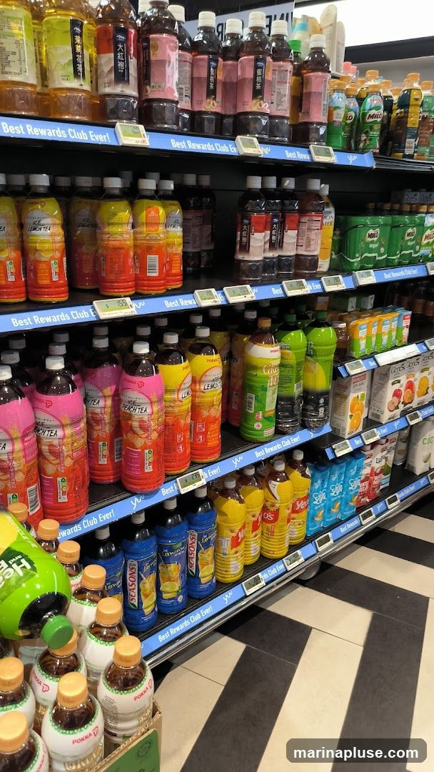 A selection of bottled beverages, including teas and lemonades, are neatly arranged on store shelves. The shelves are labeled with "Best Rewards Club Ever!". Some bottles are in the foreground, while others recede into the background.