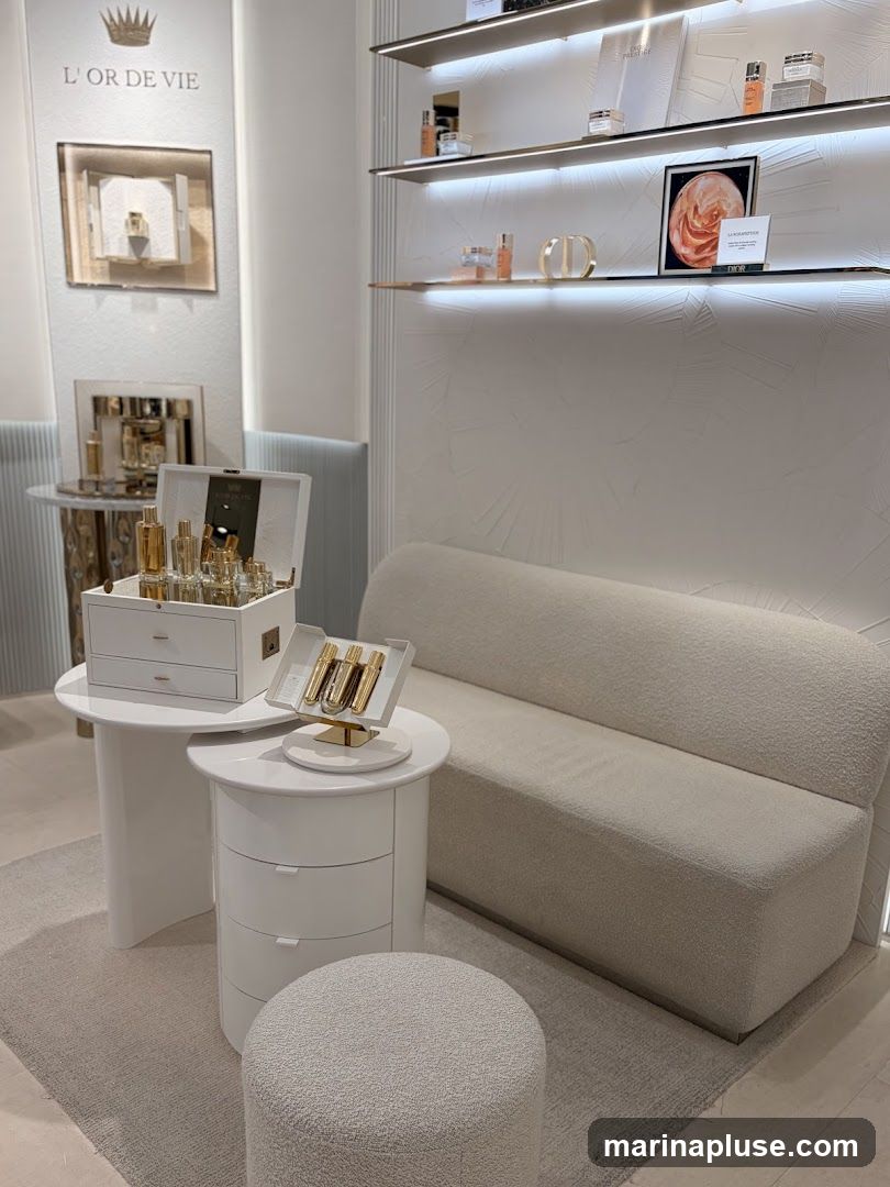 A well-lit interior display of high-end cosmetics. Products are arranged on shelves and tables, with a plush sofa and ottoman for seating. The branding "L'OR DE VIE" is visible on a vertical display.