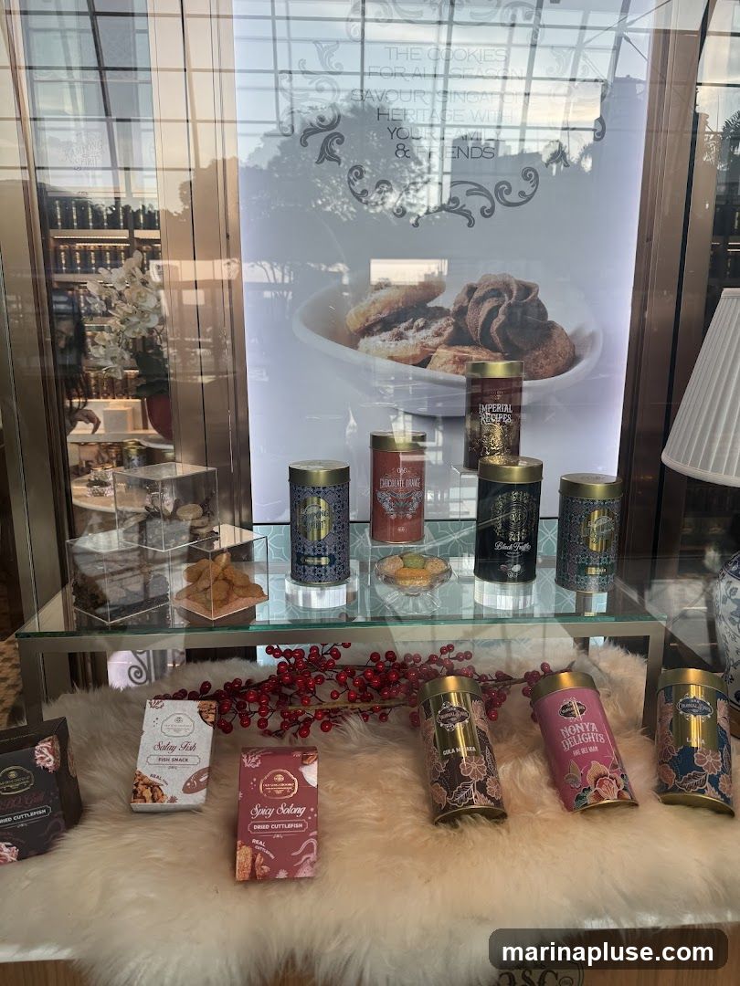 A display of various cookies and snacks in decorative tins and boxes, arranged on shelves and a furry white surface. A promotional poster featuring cookies is visible in the background.