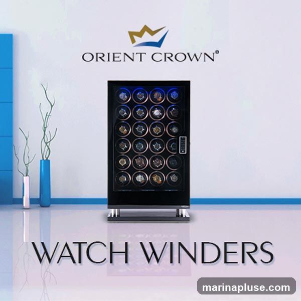 A display of watch winders with the Orient Crown logo above. The watch winders are in a black cabinet with blue interior lighting, and each compartment holds a watch. The text "WATCH WINDERS" is displayed prominently at the bottom.