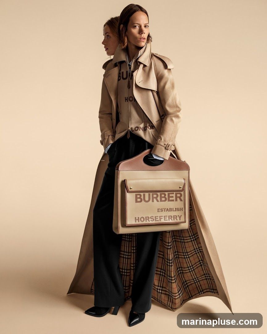 Two models are shown against a plain beige background. The model in the foreground wears a beige trench coat over a zipped jacket with the Burberry logo and "LONDON" printed on it. She also wears black trousers and black heels. She holds a beige and brown Burberry bag with "BURBERR ESTABLISH HORSEFERRY" printed on it. The lining of her trench coat features the iconic Burberry check pattern. A second model is partially visible behind her, also wearing a trench coat.