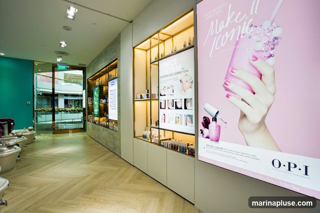 The interior of a nail salon features pedicure chairs, shelves stocked with nail products, and promotional posters. One poster advertises OPI Gel Color, while another details a brace system for ingrown nail correction. An exit sign is visible through a glass door.