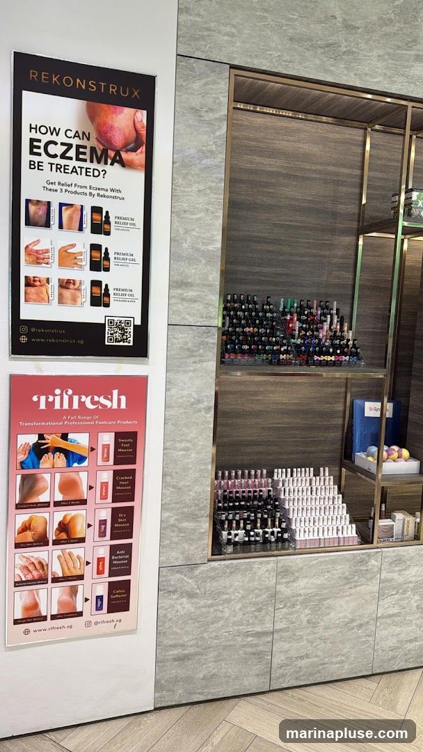 Two posters are displayed on a wall. The top poster, for Rekonstrux, asks "How Can Eczema Be Treated?" and advertises three products: Premium Relief Oil, Premium Relief Gel, and Premium Relief Balm. The bottom poster, for Rifresh, advertises a range of transformational professional footcare products, including Sweaty Feet Mousse, Cracked Heel Mousse, Dry Skin Mousse, Anti Bacterial Mousse, and Callus Softener. Behind the posters, shelves display numerous bottles of nail polish and other cosmetic products.