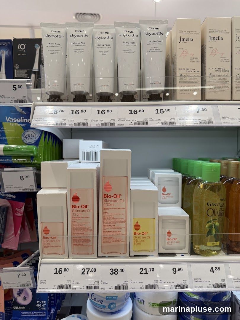A retail display shelf featuring various skincare products, including hand creams from Skybottle and Jmella, Bio-Oil skincare oils and dry skin gel, and Ginvera Pure Olive Oil. Prices are visible for most items.