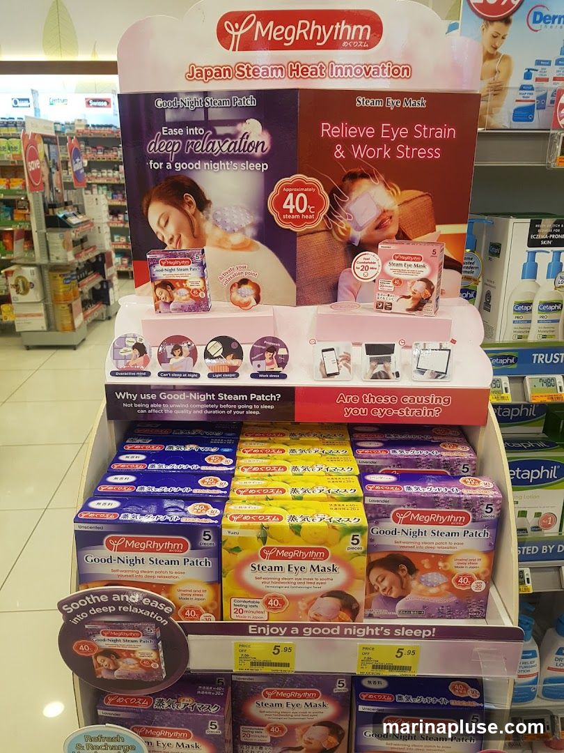 A retail display featuring MegRhythm Good-Night Steam Patches and Steam Eye Masks. The display highlights Japan Steam Heat Innovation, with claims of deep relaxation and relief from eye strain and work stress. Various scents and types are shown, including Unscented, Yuzu, and Lavender. Promotional text emphasizes soothing and easing into relaxation. Prices of 5.95 are visible for some items.
